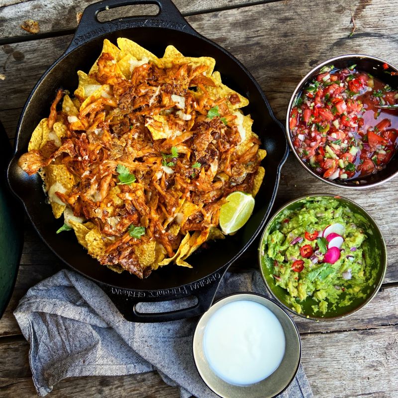 Nacho's met pulled BBQ chicken, guacamole, tomatensalsa en crème fraîche